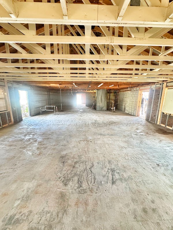 Pizza Hut interior in Manitowoc after strip-out, with exposed framing and a cleared floor